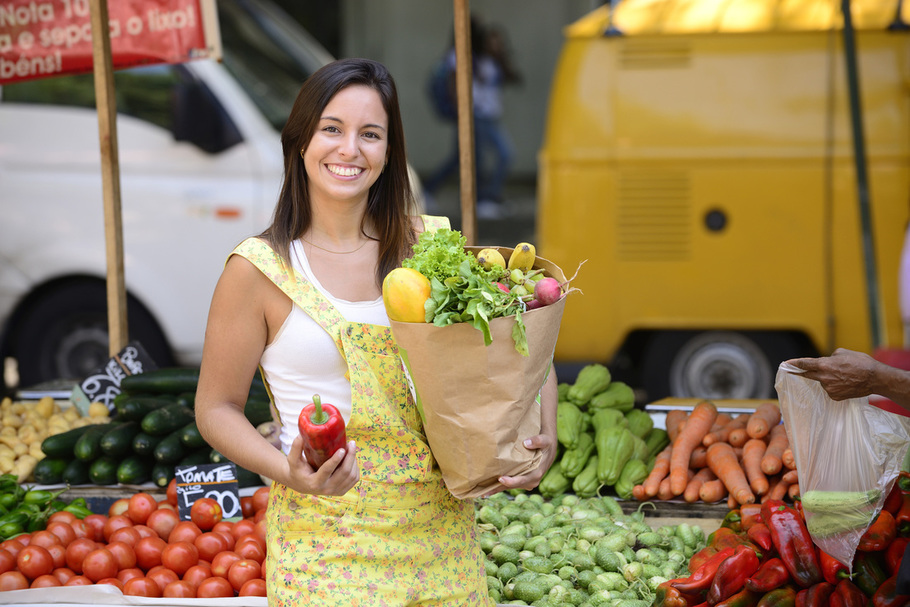 Smiling woman buying vegetables at farmers market