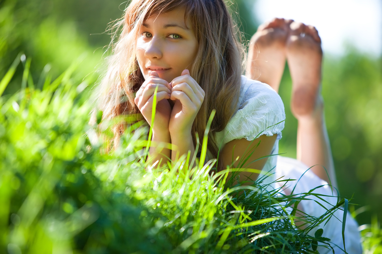 Young woman on green meadow grass
