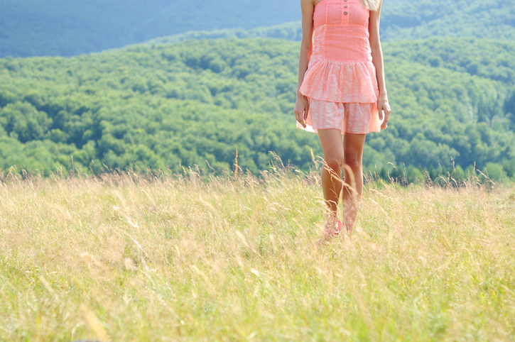 Woman walking in a summer meadow