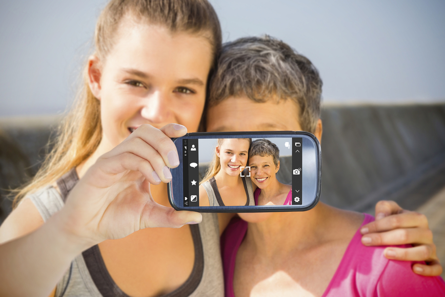 Snapshot of mother and daughter taking selfie